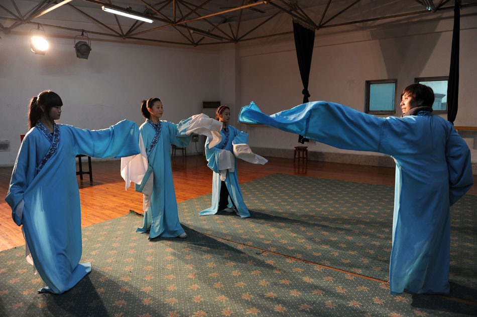 Wu Fenghua (1st R) gives instructions to her students in Xiaobaihua Shaoxing Opera Troupe in Shaoxing, east China's Zhejiang Province, Dec. 10, 2011. (Xinhua/Ju Huanzong)