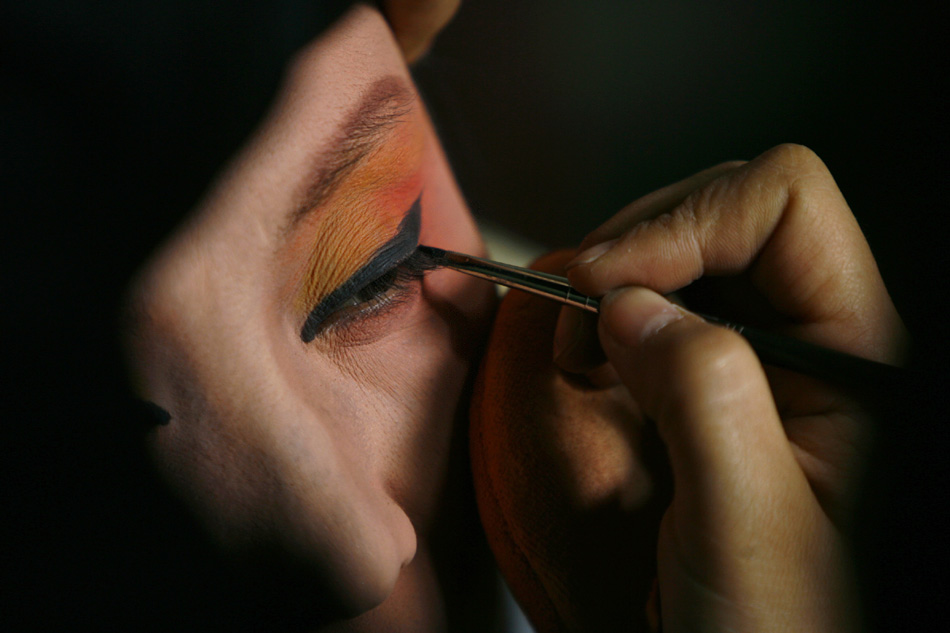 Wu Fenghua gets her makeup on before a night show in Qianqing Village in Shaoxing, east China's Zhejiang Province, Jan. 31, 2012. (Xinhua/Cui Xinyu)  