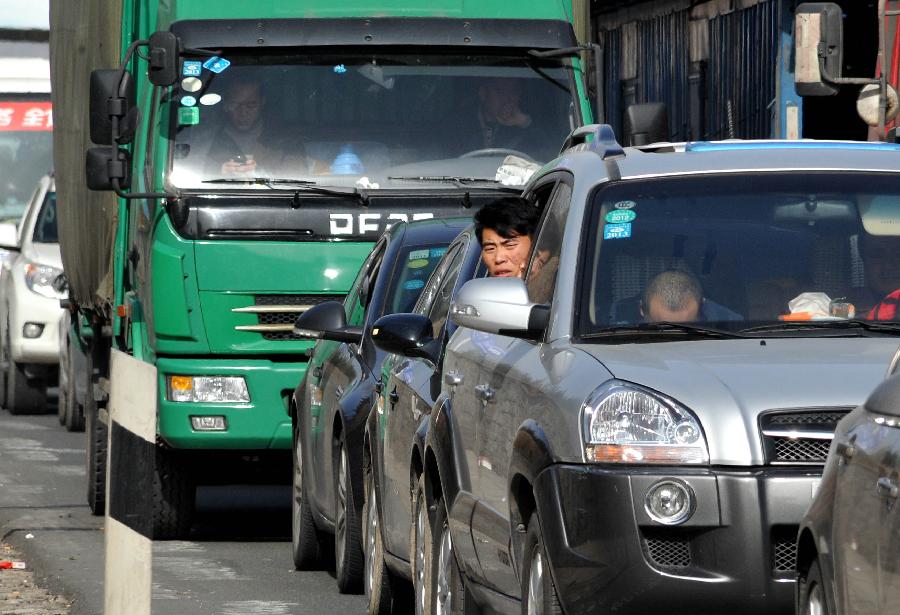 Passengers wait in a car on the Jingtai Highway in Jinan, east China's Shandong Province, Nov. 26, 2012. Several traffic accidents happened on the highway and caused a traffic jam on Monday. (Xinhua/Xu Suhui) 