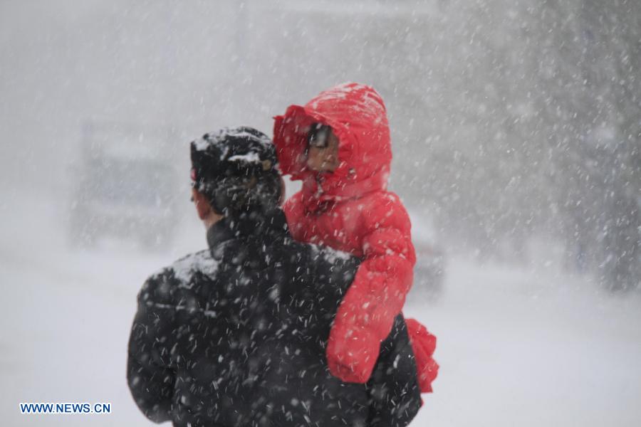 Citizens walk in the snow on a street in Altay, northwest China's Xinjiang Uygur Autonomous Region, Nov. 26, 2012. Heavy snow hit Altay since last Monday, bringing inconveniences to the herdsmen and traffic here. (Xinhua/Tang Xiaobo) 