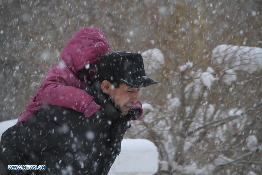 Citizens walk in the snow on a street in Altay, northwest China's Xinjiang Uygur Autonomous Region, Nov. 26, 2012. Heavy snow hit Altay since last Monday, bringing inconveniences to the herdsmen and traffic here. (Xinhua/Tang Xiaobo) 