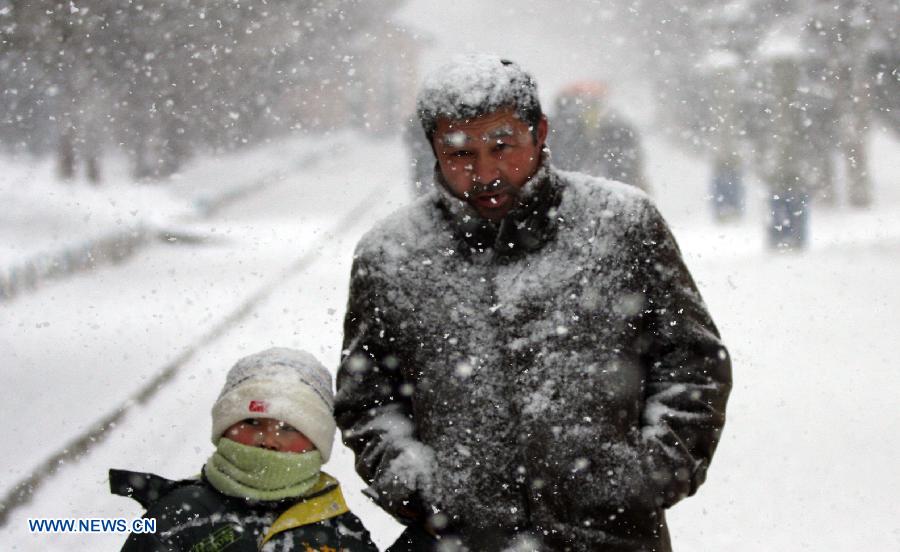 Citizens walk in the snow on a street in Altay, northwest China's Xinjiang Uygur Autonomous Region, Nov. 26, 2012. Heavy snow hit Altay since last Monday, bringing inconveniences to the herdsmen and traffic here. (Xinhua/Zhang Xiuke) 