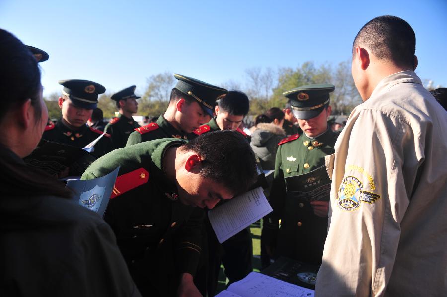 A veteran of Chinese national flag escort registers personal information in Beijing, capital of China, Nov. 23, 2012. More than 40 companies came to the escort to employ the demobilized veterans on Friday. (Xinhua/Liu Changlong)