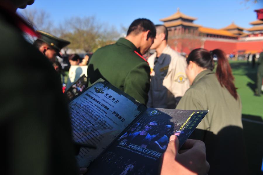 A veteran of Chinese national flag escort watches employment information in Beijing, capital of China, Nov. 23, 2012. More than 40 companies came to the escort to employ the demobilized veterans on Friday. (Xinhua/Liu Changlong) 