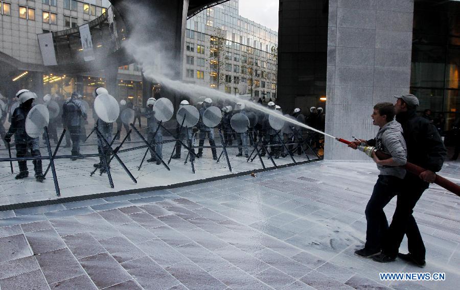 Dairy farmers spray milk to European Parliament building during a protest against EU agricultural policies at the Place du Luxembourg in Brussels, capital of Belgium, on Nov. 26, 2012. Dairy farmers from all over Europe demonstrated today with about 1,000 tractors at the European Parliament in Brussels to protest against falling milk prices caused by overproduction in the continent. (Xinhua/Zhou Lei) 