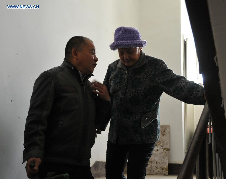 Zhu Qingzhang hands his adoptive mother Han Fuzhen down the stairs in Baotou, north China's Inner Mongolia Autonomous Region, Nov. 27, 2012. An accident left Zhu Qingzhang's adoptive mother Han Fuzhen in a vegetative state in 1975. Since then, Zhu has been looking after his adoptive mother while doing his own job. And all his love for his adoptive mother paid off when Han finally woke up 31 years later. Under the care of 62-year-old Zhu, 86-year-old Han now lives a happy and healthy life. (Xinhua/Liu Yide) 