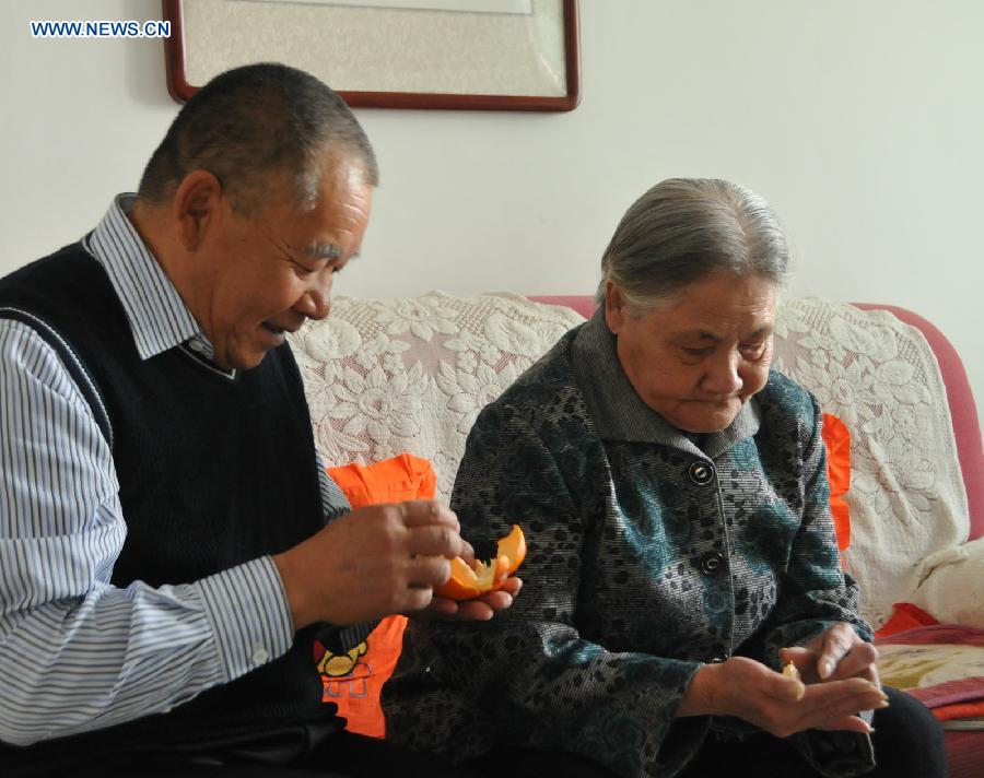 Zhu Qingzhang peels an orange for his adoptive mother Han Fuzhen at home in Baotou, north China's Inner Mongolia Autonomous Region, Nov. 27, 2012. An accident left Zhu Qingzhang's adoptive mother Han Fuzhen in a vegetative state in 1975. Since then, Zhu has been looking after his adoptive mother while doing his own job. And all his love for his adoptive mother paid off when Han finally woke up 31 years later. Under the care of 62-year-old Zhu, 86-year-old Han now lives a happy and healthy life. (Xinhua/Liu Yide) 