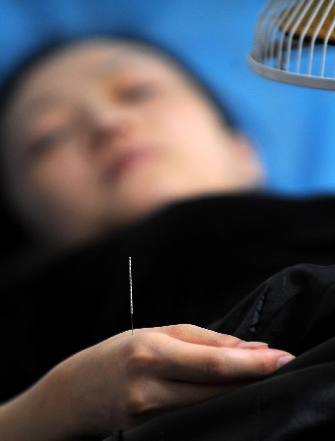 A woman receives acupuncture in Taiyuan, capital of north China's Shanxi Province, Nov. 23, 2012. More and more Chinese are disposed to preventive treatment of discease rather than curative treatment, they receive acupuncture, moxibustion, herbal paste or other Chinese traditional regimen to improve sub-healthy state.(Xinhua/Yan Yan) 