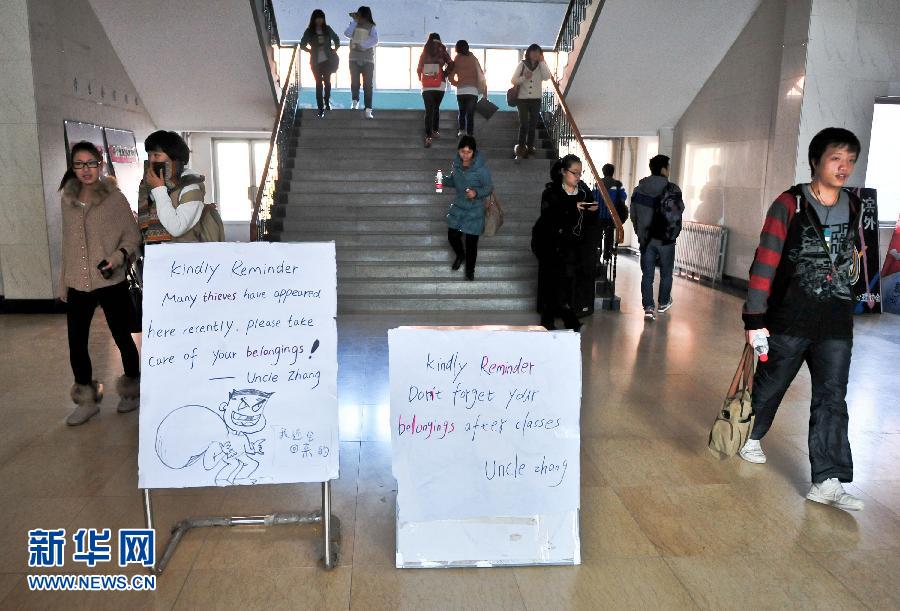 Zhang Weike puts the bulletin board at the entrance to a school building on Nov 27, 2012. (Xinhua/Zhang Chaoqun)