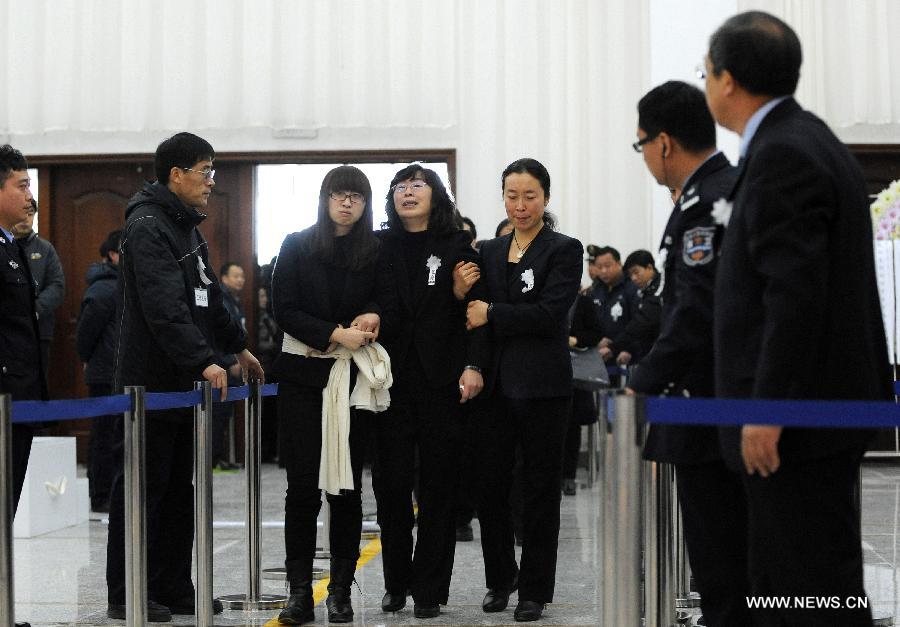 Wang Xili (C) cries as attending a memorial service for her husband Luo Yang, head of the production phase for China's new J-15 fighter jet, who died of a heart attack on Nov. 25, in the Huilonggang Cemetery for Revolutionaries in Shenyang, capital of northeast China's Liaoning Province, Nov. 29, 2012. Luo experienced a heart attack after observing aircraft carrier flight landing tests for China's first aircraft carrier, the Liaoning, on Nov. 25. He later died in hospital at the age of 51. He was also chairman and general manager of Shenyang Aircraft Corp. (SAC), a subsidiary of China's state-owned aircraft maker, Aviation Industry Corp. of China (AVIC). (Xinhua/Li Gang) 