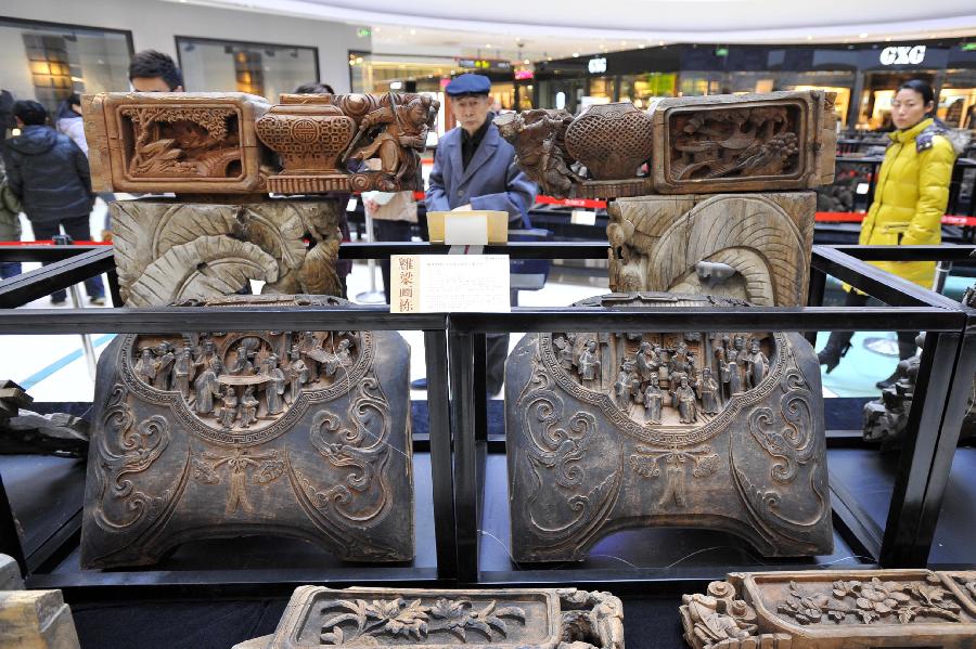 People visit an exhibition of ancient Chinese architectural woodcarving components in Jinan, capital of east China's Shandong Province, Nov. 29, 2012. (Xinhua/Guo Xulei)