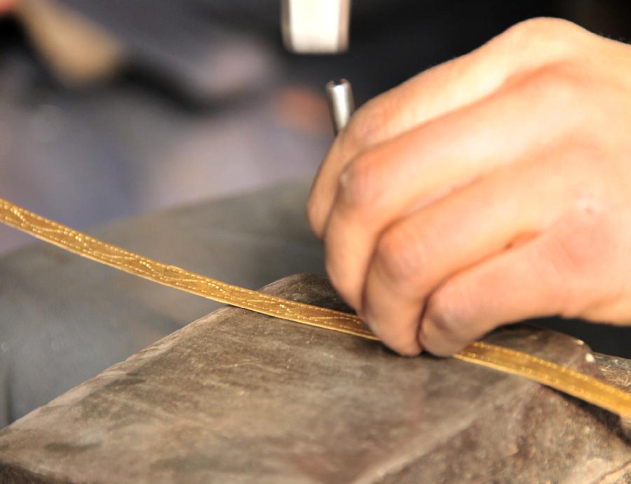 A craftsman of China's Bao'an ethnic group make accessory parts on broadswords in Jishishan County, northwest China's Gansu Province, Nov. 29, 2012. (Xinhua/Huang Wenxin) 