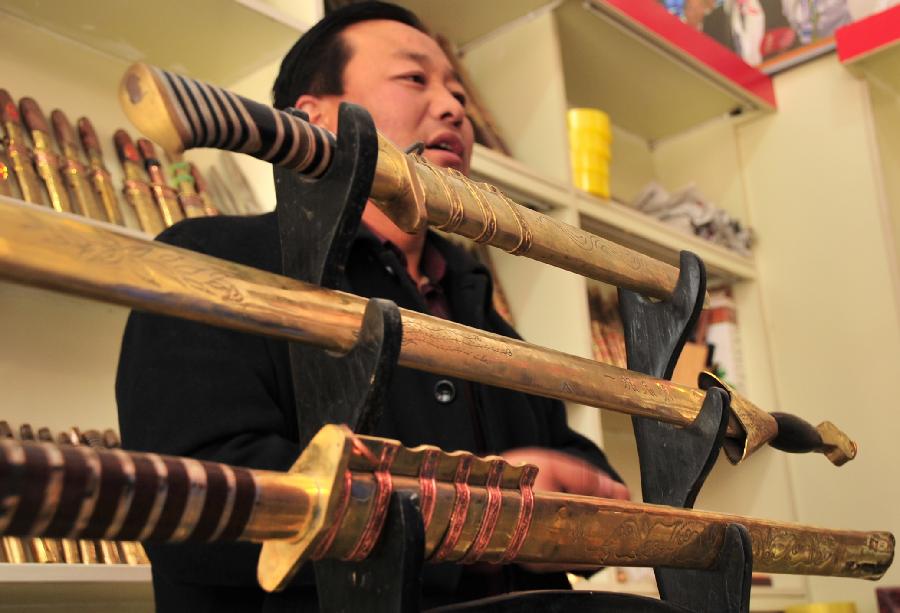 Ma Zizheng, a professional Bao'an broadsword maker, introduces Bao'an broadswords at his store in Jishishan County, northwest China's Gansu Province, Nov. 29, 2012.  (Xinhua/Huang Wenxin) 