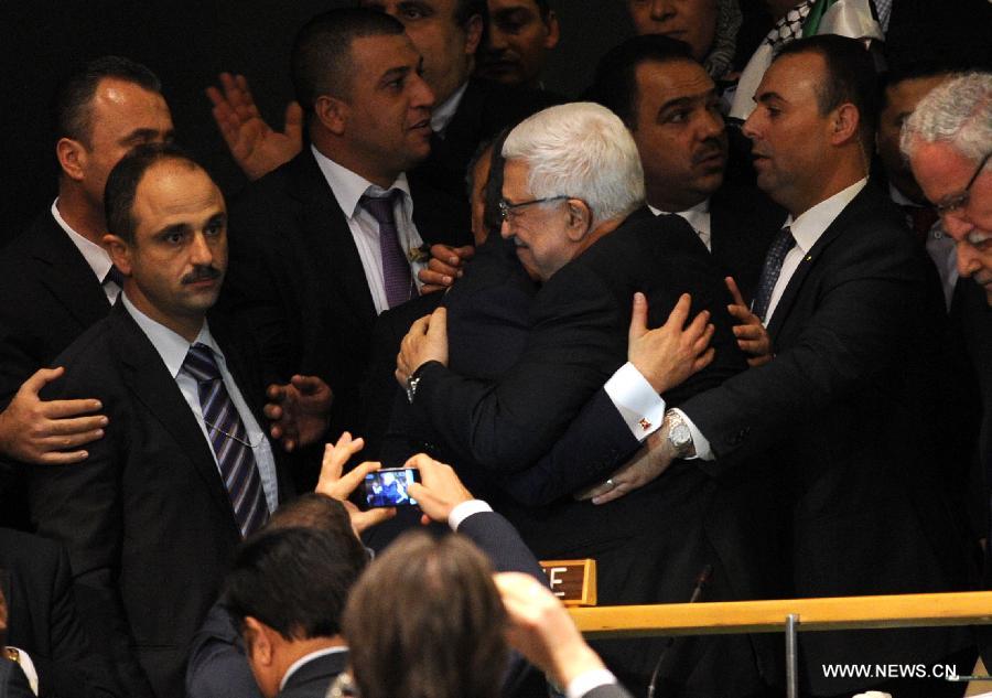 Palestinian President Mahmoud Abbas (C) gets a hug from Turkey's Foreign Minister Ahmet Davutoglu at the UN General Assembly (UNGA) meeting at the UN headquarters in New York, the United States, on Nov. 29, 2012. The UNGA on Thursday voted overwhelmingly to grant an upgrade of the Palestinians status at the United Nations from "entity" to "non-member state". (Xinhua/Shen Hong)