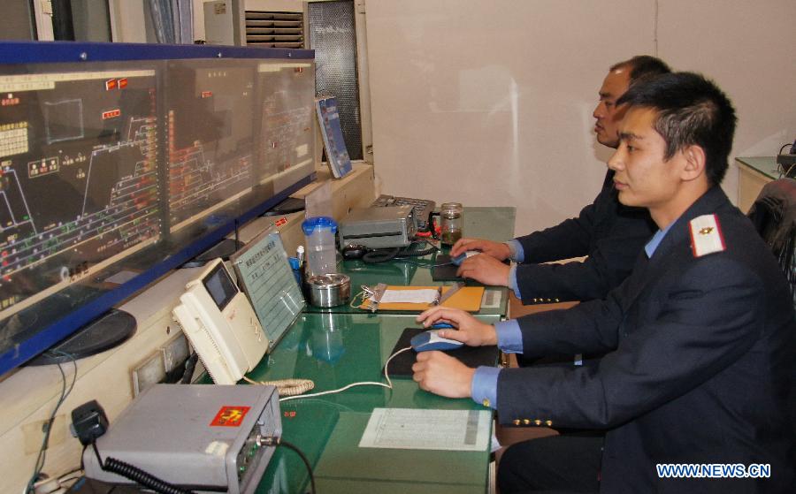 Technicians monitor the indicating maps of signals at the signal mechanical room of the Baotou East Station of the Baotou electricity section of the Hohhot Railway Bureau in Baotou, north China's Inner Mongolia Autonomous Region, Nov. 29, 2012. Facing the low temperatures, strong winds and snowfalls since winter, the Hohhot Railway Bureau has organized all its departments to guarantee the rail transport in winter, including activities like strengthening vehicle scheduling and security inspection during on-site operations. (Xinhua/Zhao Tingting)