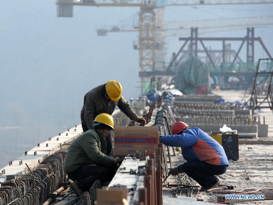 Laborers work on the Bapanxia Yellow River bridge of the second line of Lanxin (Lanzhou-Xinjiang) Railway in Yongqing, northwest China's Gansu Province, Nov. 26, 2012.