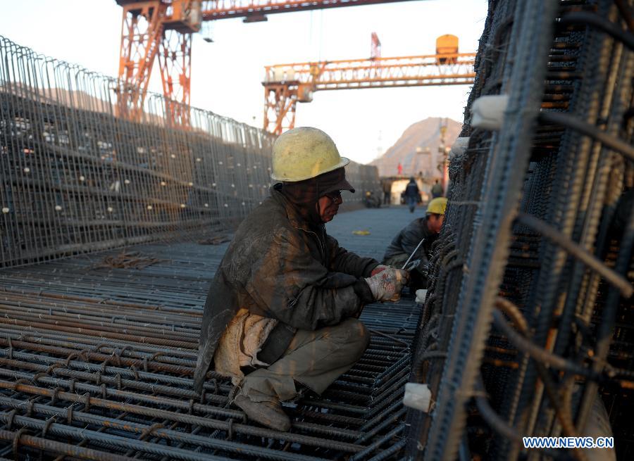 Laborers work on the Huangshuihe River bridge of the second line of Lanxin (Lanzhou-Xinjiang) Railway in Pingan County, northwest China's Qinghai Province, Nov. 26, 2012. 