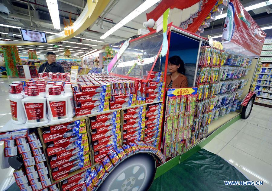 A woman is seen in a her truck-shaped stand with toothpastes and brushes at a supermarket in Hangzhou, capital of east China's Zhejiang Province, Nov. 28, 2012. A competion of creative laying of commodities was held here on Wednesday to draw customers' attention. (Xinhua/Shi Jianxue)