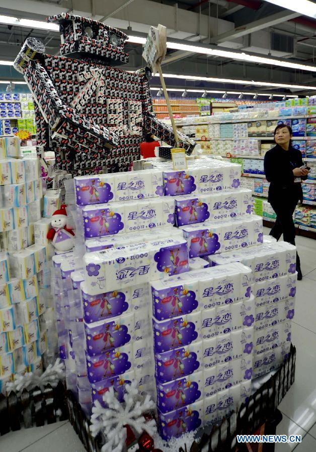 A customer walks past a robot-shaped stand at a supermarket in Hangzhou, capital of east China's Zhejiang Province, Nov. 28, 2012. A competion of creative laying of commodities was held here on Wednesday to draw customers' attention. (Xinhua/Shi Jianxue)