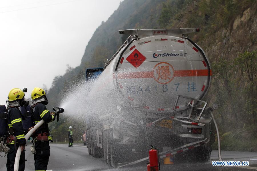 Rescuers apply dilution measures to acetone leakage at the scene of a rear-end collision in a section of the Chongqing-Changsha Expressway in Apengjiang Town, Qianjiang District, southwest China's Chongqing Municipality, Nov. 28, 2012. 