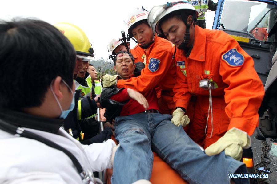 Rescuers save a cargo truck driver at the scene of a rear-end collision in a section of the Chongqing-Changsha Expressway in Apengjiang Town, Qianjiang District, southwest China's Chongqing Municipality, Nov. 28, 2012. 