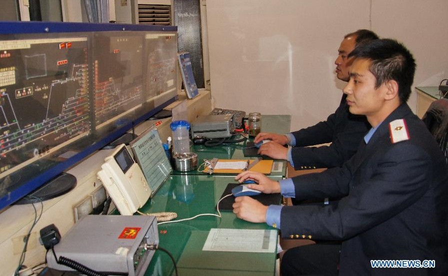 Technicians monitor the indicating maps of signals at the signal mechanical room of the Baotou East Station of the Baotou electricity section of the Hohhot Railway Bureau in Baotou, north China's Inner Mongolia Autonomous Region, Nov. 29, 2012. Facing the low temperatures, strong winds and snowfalls since winter, the Hohhot Railway Bureau has organized all its departments to guarantee the rail transport in winter, including activities like strengthening vehicle scheduling and security inspection during on-site operations. (Xinhua/Zhao Tingting) 