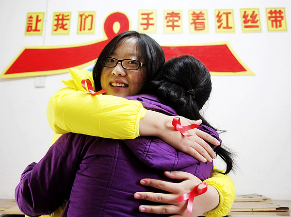 Wang Ruihuan, left, a volunteer at University of South China, embraces an AIDS patient in Hengyang, Central China's Hunan province on Nov 29, 2012. To mark the World AIDS Day on Dec 1, volunteers from the university are working with the Third People's Hospital of Hengyang to reach out to AIDS patients. (Xinhua)