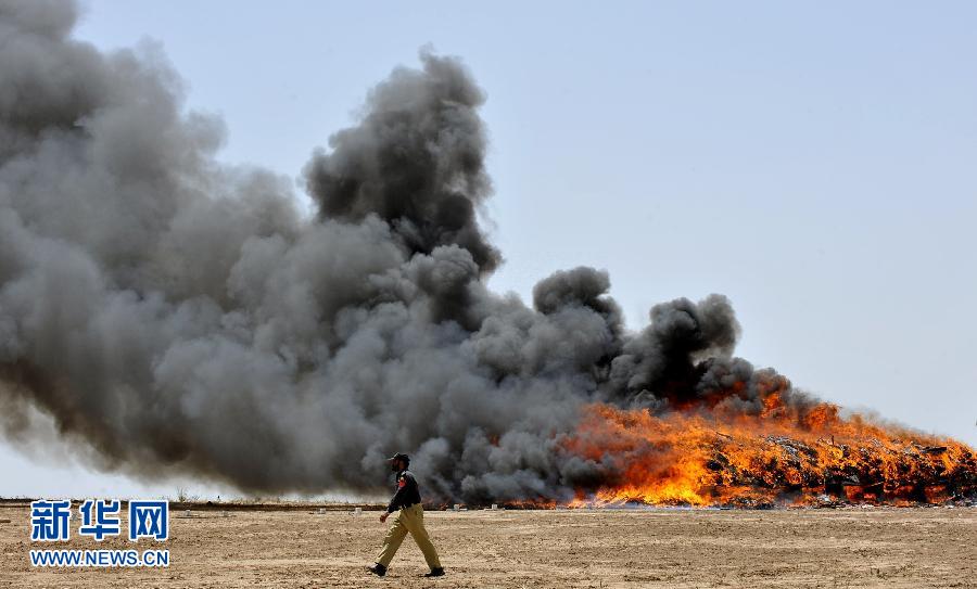 A drug-enforcement police officer walks past a pile of burning drugs in Rawalpindi, Pakistan on June 26, 2012. Syringe sharing among drug users caused many HIV transmissions, so keeping away from drug can effectively prevent HIV spreading. (Xinhua/AFP)