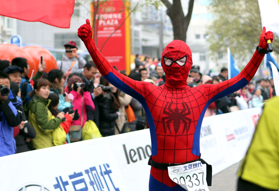 A runner dressed in Spiderman costume raises up hands as rushing for the finishing line in 2012 Beijing International Marathon, which brought around 30, 000 marathon runners to China’s capital on Nov. 25, 2012. (Xinhua/Han Yan)