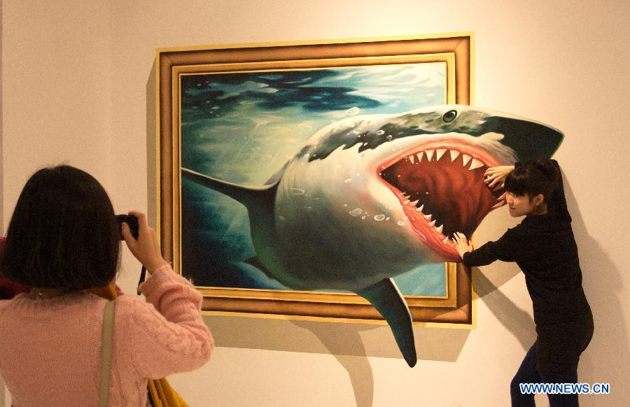 A visitor poses with a three dimensional painting during an exhibition in Tianjin, north China, Dec. 1, 2012. (Xinhua/Wang Qingyan)