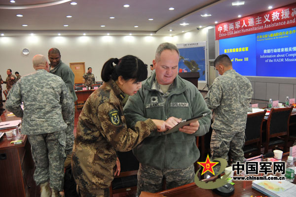 Two officers from the two sides are exchanging views during the interval of the tabletop exercise. (PLA Daily/Yang Liming)