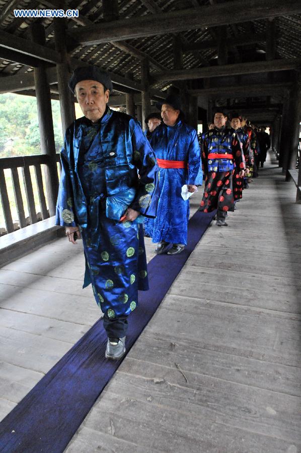 People of the Dong ethnic group walk through the Chengyang Fengyu Bridge during a celebration ceremony marking the 100th anniversary of its completion held in Sanjiang Dong Autonomous County, south China's Guangxi Zhuang Autonomous Region, Dec. 1, 2012. (Xinhua/Lai Liusheng) 