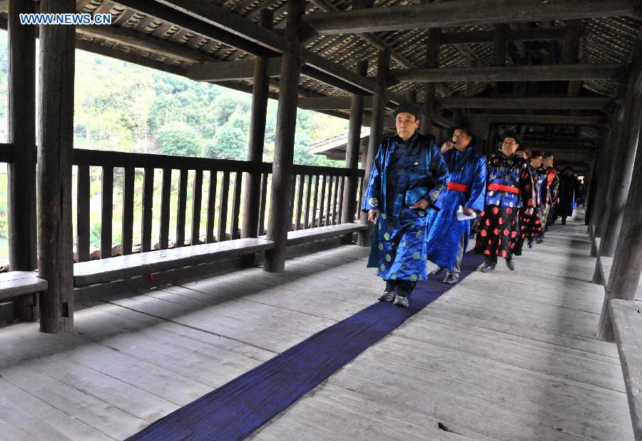 People of the Dong ethnic group walk through the Chengyang Fengyu Bridge during a celebration ceremony marking the 100th anniversary of its completion held in Sanjiang Dong Autonomous County, south China's Guangxi Zhuang Autonomous Region, Dec. 1, 2012. (Xinhua/Lai Liusheng) 