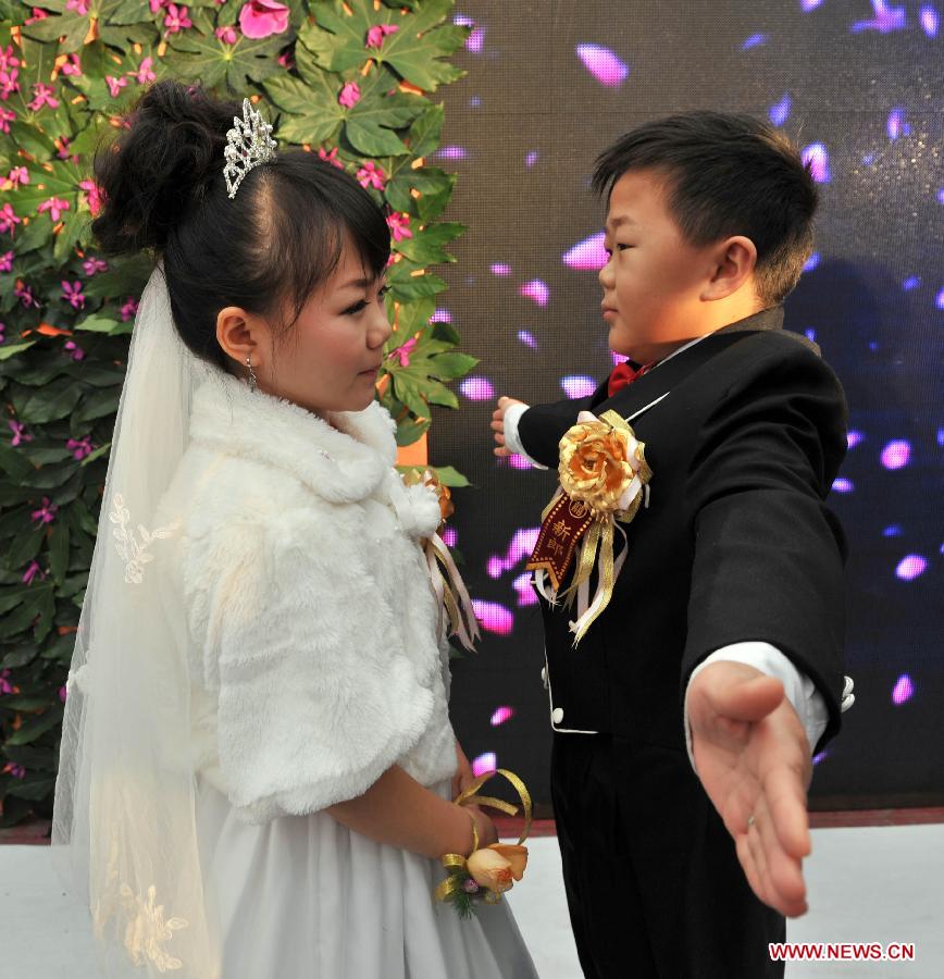 A couple embrace each other during a group wedding in Beijing, capital of China, Dec. 1, 2012. Seven couples who are about 126-centimeter-tall from a Beijing shadow play troupe attended the group wedding on Saturday. (Xinhua/Li Wen) 