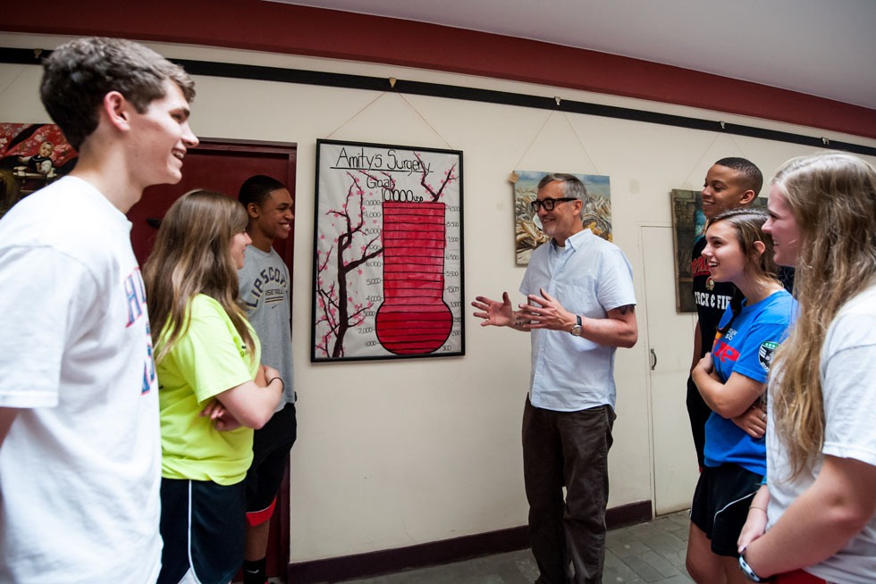 Tim Baker (4th L) tells a story of raising surgery funds for a kid called Amity to some American high school students, who are going to be volunteers for one week, at the Shepherd's Field in Tianjin, north China, May 29, 2012.(Xinhua/Zhang Chaoqun)