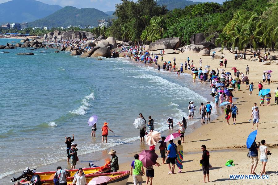 Tourists visit the Tianya Haijiao ("Edges of the heaven, corners of the sea") resort in Sanya, south China's Hainan Province, Dec. 1, 2012. Sanya has always been a winter tourism preference thanks to its tropical climate. (Xinhua/Hou Jiansen)