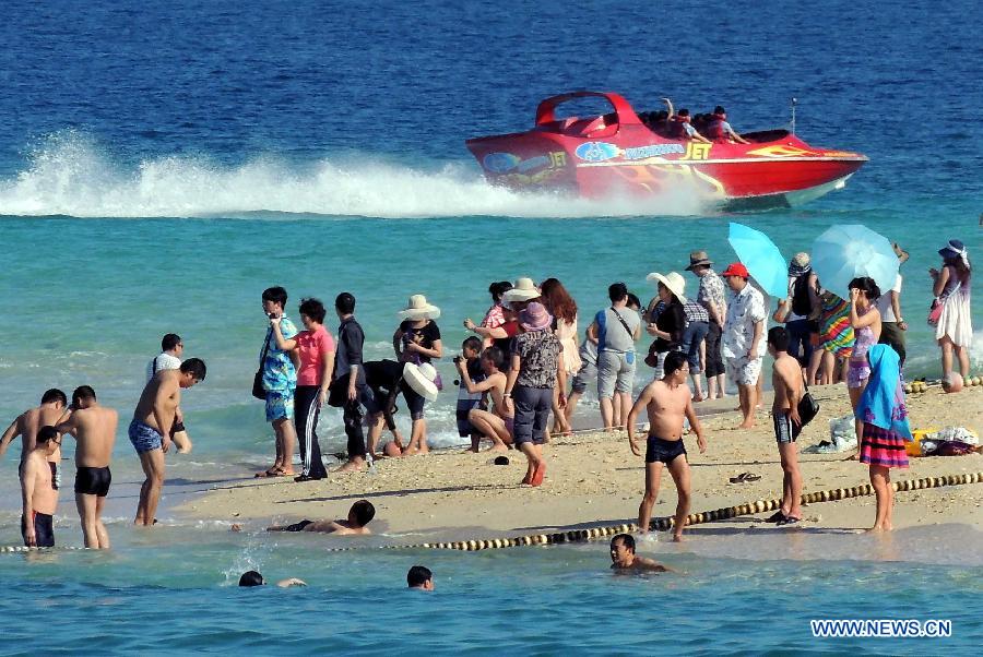 Tourists enjoy the seaside of Wuzhizhou Island, a scenic spot in Sanya, south China's Hainan Province, Dec. 1, 2012. Sanya has always been a winter tourism preferrence thanks to its tropical climate. (Xinhua/Wang Song) 