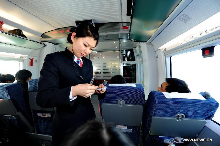 A conductor checks tickets on the D5006 high-speed train from Changchun, capital of northeast China's Jilin Province, Dec. 1, 2012. (Xinhua/Zhang Nan) 