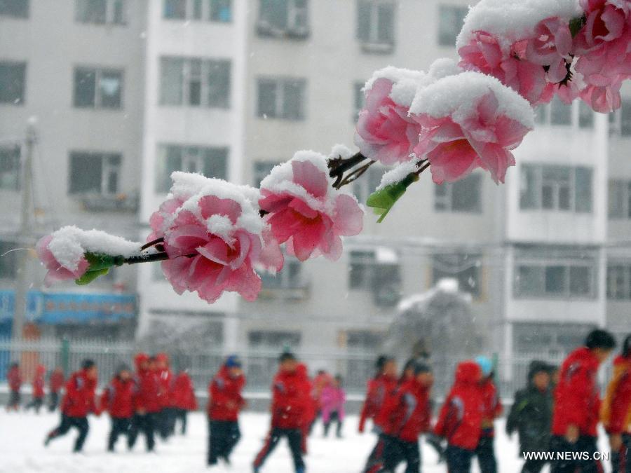 Students play on the playground amid snowstorm at Songjiang Experimental Primary School in Jilin, northeast China's Jilin Province, Dec. 3, 2012. Snow fell in most parts of the northeast of China, and local area had a blizzard. Liaoning Province issued a continuous blizzard warning signal from early Monday morning, while issuing the first alert for the blizzard at Shenyang and other areas. (Xinhua) 