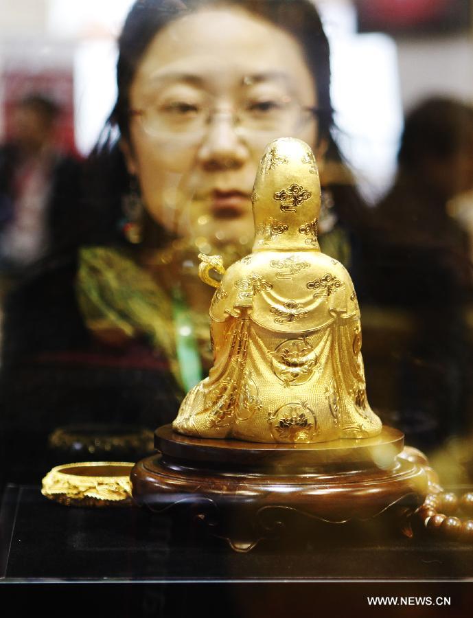 A visitor watches a work of art which is made of gold at the 8th Beijing International Finance Conference in Beijing, capital of China, Dec. 3, 2012. The four-day conference was closed on Monday. (Xinhua/Wang Shen)