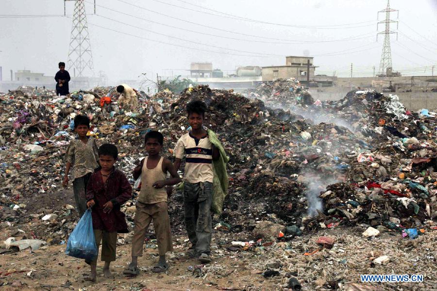 Children search for usable items in a garbage dump site near the Arabian Sea, in southern Pakistani port city of Karachi, on Dec. 3, 2012. Environmental issues in Pakistan threaten the population's health and have been disturbing the balance between economic development and environmental protection. (Xinhua/Arshad)