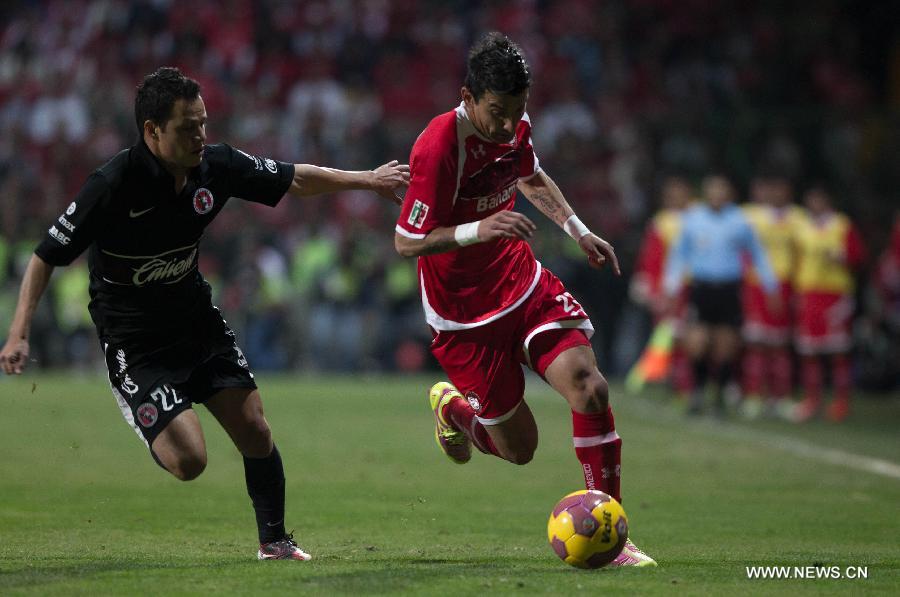 Player Edgar BenItez (R) of Toluca vies for the ball with Juan Carlos Nunez (L) of Tijuana during their Mexican Apertura tournament final football match, held at the Nemesio Diez stadium, in Toluca, State of Mexico, Mexico, on Dec. 2, 2012. (Xinhua/Pero Mera) 