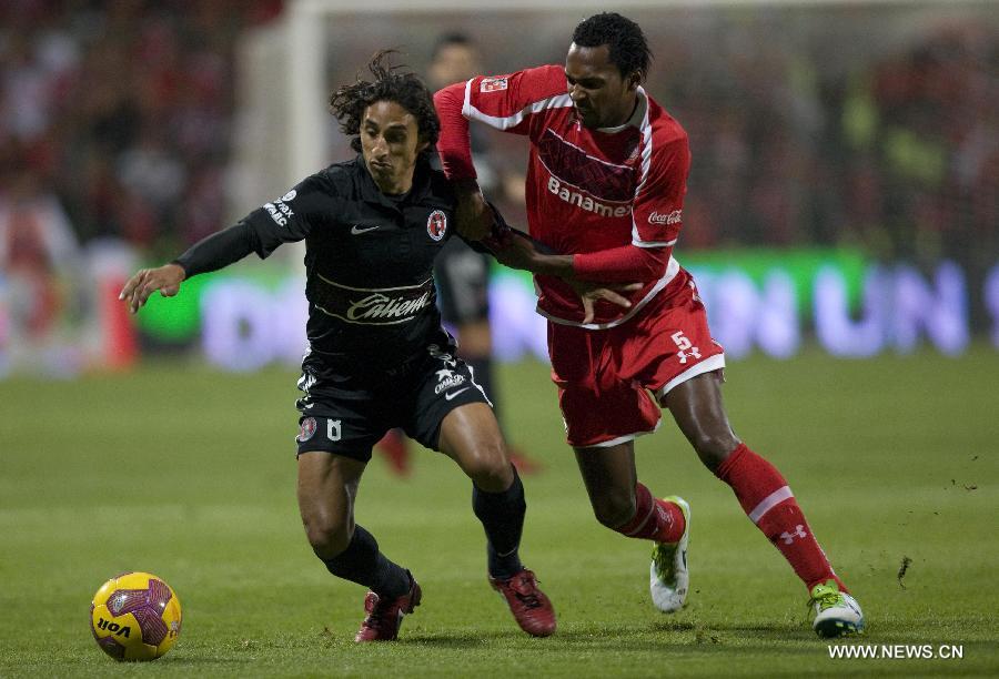 Player Wilson Tiago (R) of Toluca vies for the ball with Fernando Arce (L) of Tijuana during their Mexican Apertura tournament final football match, held at the Nemesio Diez stadium, in Toluca, State of Mexico, Mexico, on Dec. 2, 2012. (Xinhua/David de la Paz)