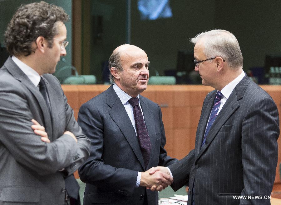 Spanish Economy Minister Luis de Guindos (C) shakes hands with EU Commissioner for Economic and Monetary affairs Olli Rehn (R) while Dutch Finance Minister Jeroen Dijsselbloem looks on during a Eurogroup finance ministers meeting at EU's headquarters on December 3, 2012, in Brussels, capital of Belgium.(Xinhua/Thierry Monasse)