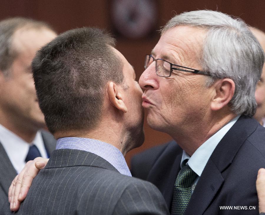 Eurogroup President Jean-Claude Juncker (R) kisses Greek Finance Minister Yannis Stournaras during a Eurogroup finance ministers meeting at EU's headquarters on December 3, 2012, in Brussels, capital of Belgium.(Xinhua/Thierry Monasse)