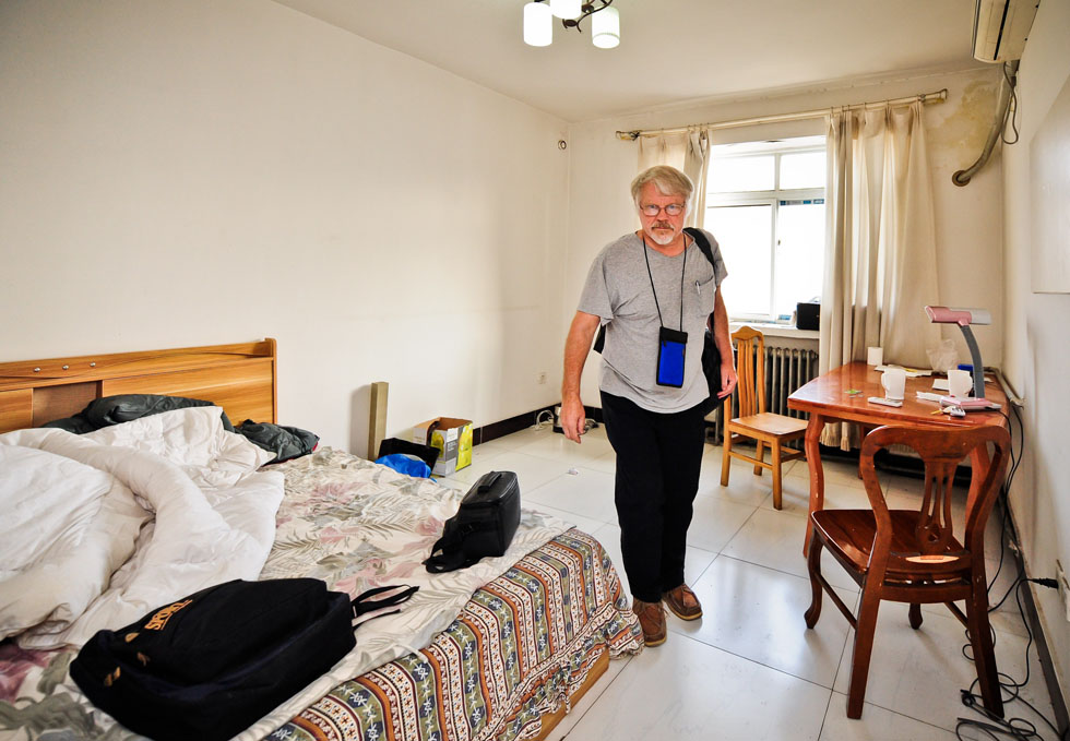 Richard Sears prepares to leave his single-room apartment and go to the airport in Tianjin, north China, Aug. 15, 2012. (Xinhua Photo)