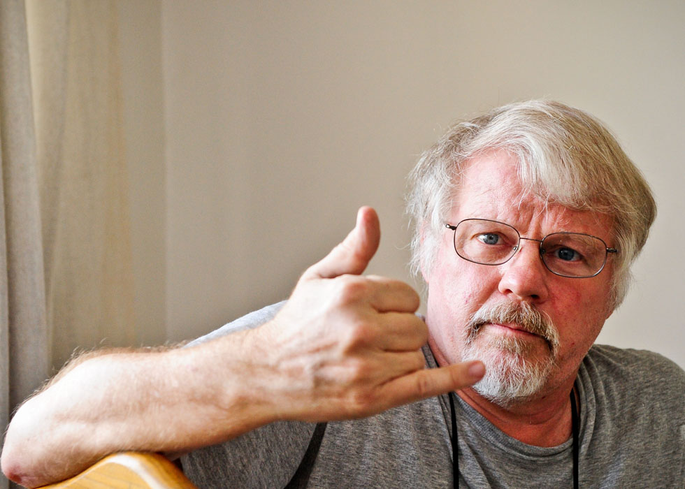 Richard Sears gestures in his single-room apartment in Tianjin, north China, Aug. 15, 2012.