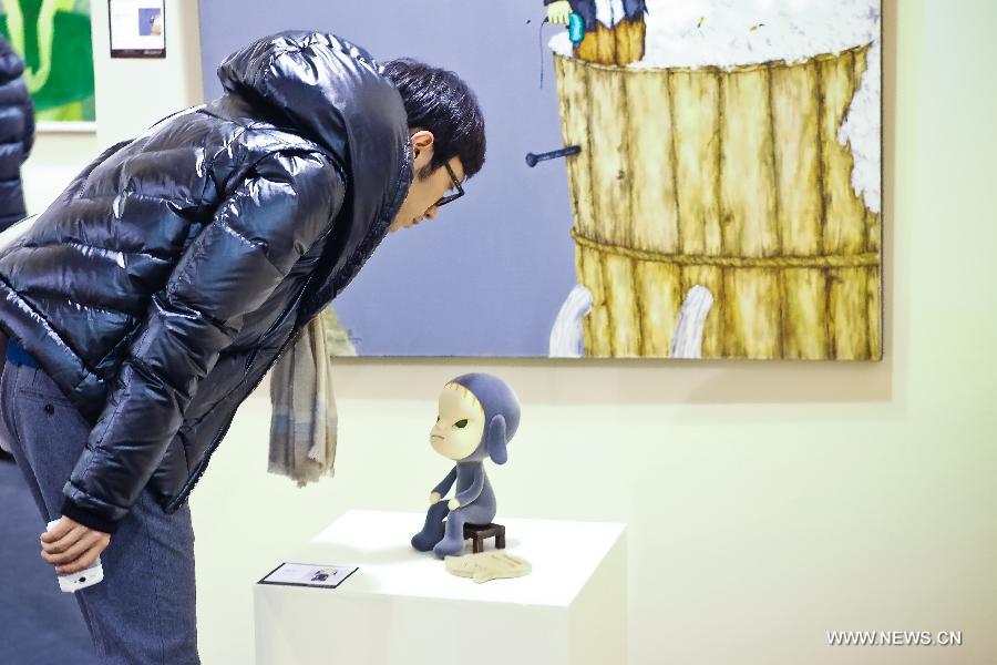 A man looks at a work displayed during the preview of Beijing Council 2012 Autumn Auction held in Beijing International Hotel Convention Center in Beijing, capital of China, Dec. 3, 2012. The preview, which kicked off on Sunday, showcased over 2500 artworks of different varieties such as paintings, chinaware and sculptures. The auction will last from Dec. 5 to Dec. 7. (Xinhua/Zhang Cheng)