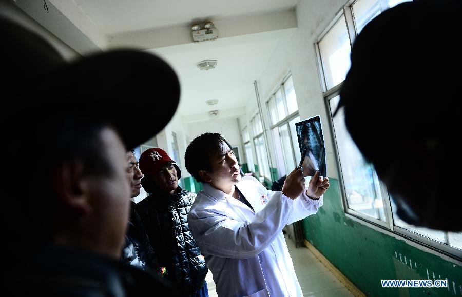 Doctor Zhang Lu (1st R) from Anhui Red Cross Cardiovascular Hospital views an X-ray chest film of a child with congenital heart disease in Nangqian County, northwest China's Qinghai Province, Dec. 3, 2012. More than 500 children here will receive free heart disease test by doctors from Anhui Red Cross Cardiovascular Hospital and 15 children with congenital heart disease will be treated for free in Hefei, capital of east China's Anhui Province. (Xinhua/Zhang Hongxiang) 
