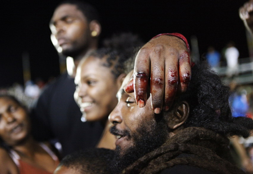 Local fighter Odille holds his bloodied hands on head after competing in eastern Trinidad on Feb 9, 2012. (Reuters/Andrea De Silva)